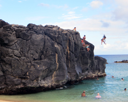 Waimea Bay in summer means cliff jumping and water activities: